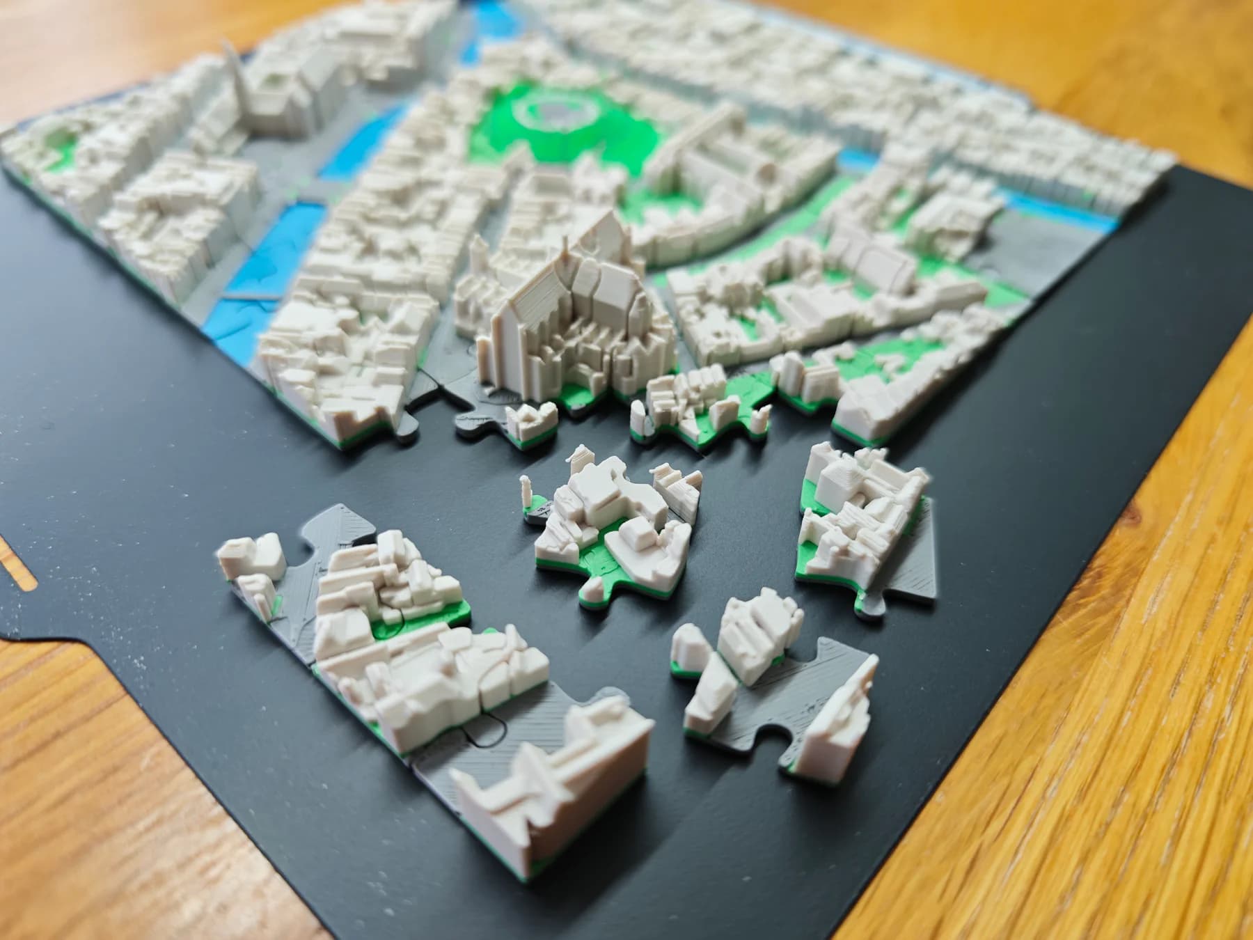 Een 3D-geprinte stadskaart die met de puzzeldoorsnijding in losse, passende stukken is verdeeld