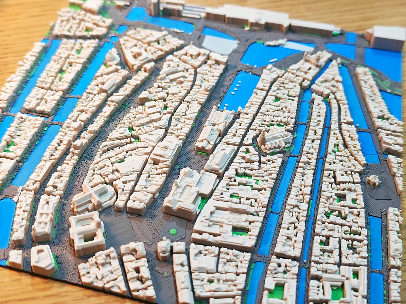 3D-geprinte stadskaart van het centrum van Amsterdam, met dicht opeengebouwde bouwblokken tussen blauwe grachten
